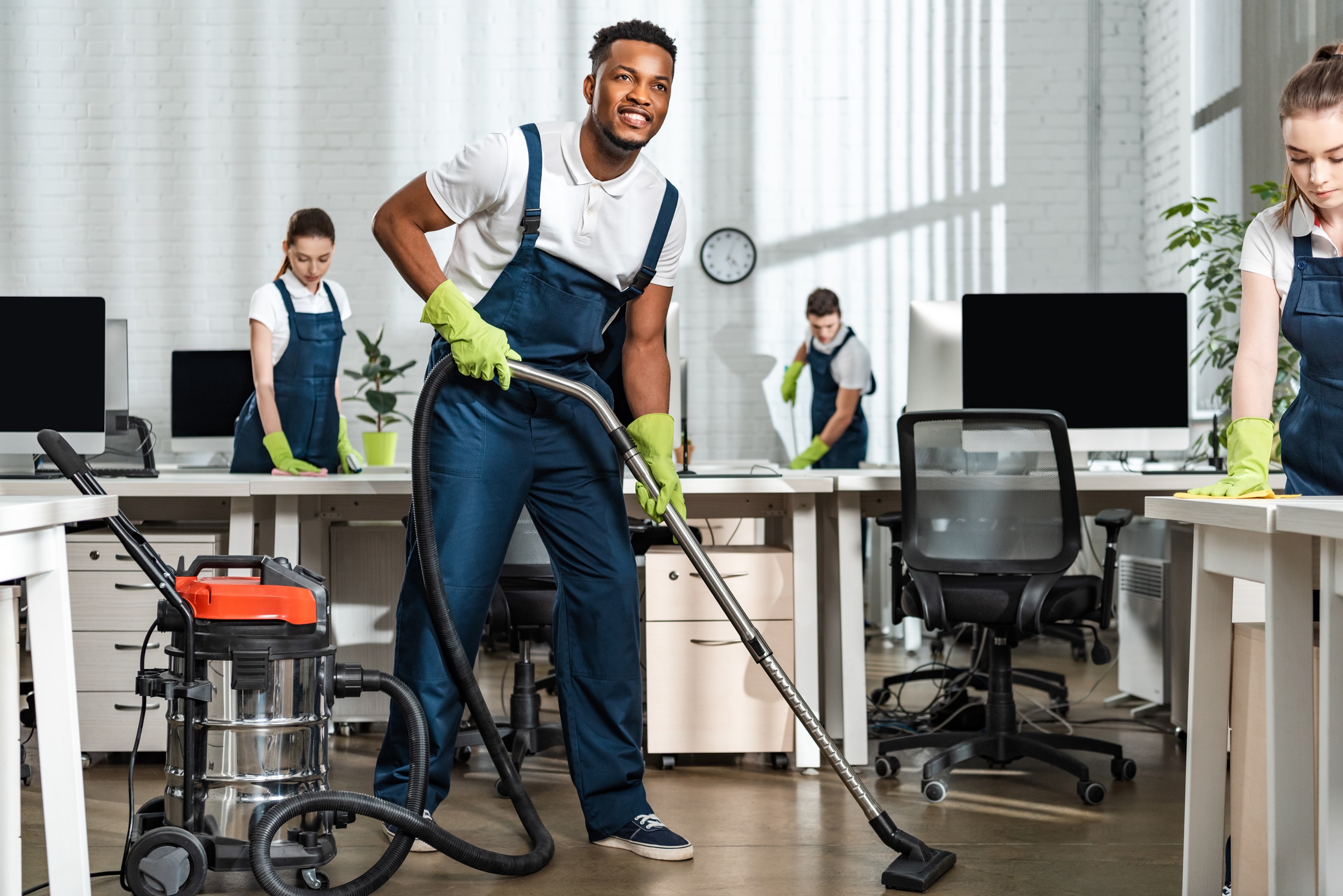 smiling african american cleaner vacuuming floor n 2023 11 27 05 11 23 utc